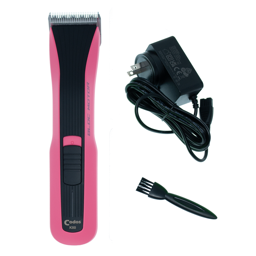 A pink and black cordless hair clipper shown with its black power adapter and a small black cleaning brush on a plain white background.